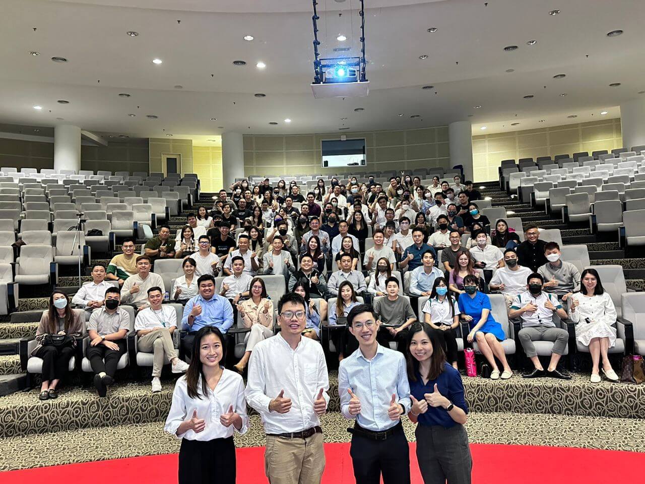 MY Psychology facilitators and workplace-session participants posing together in an auditorium at IPG Malaysia.